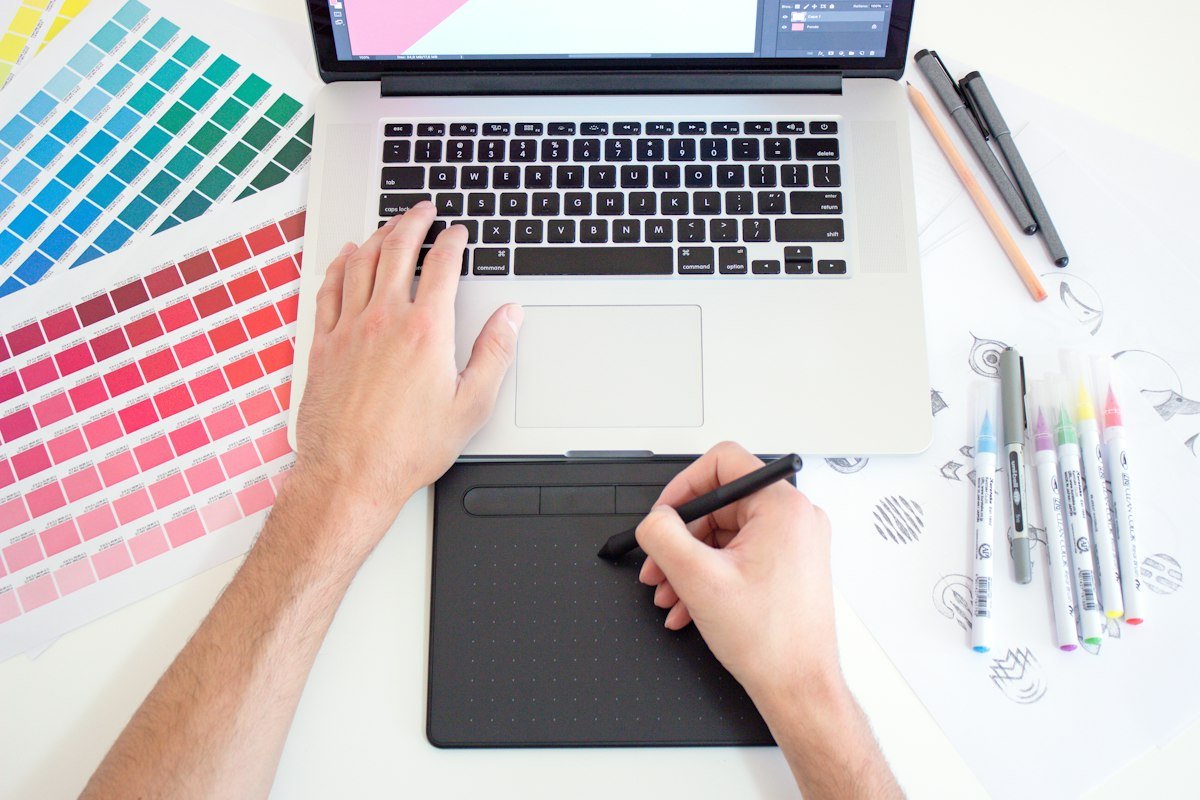 Graphic designer workspace with colour swatches and drawing tablet