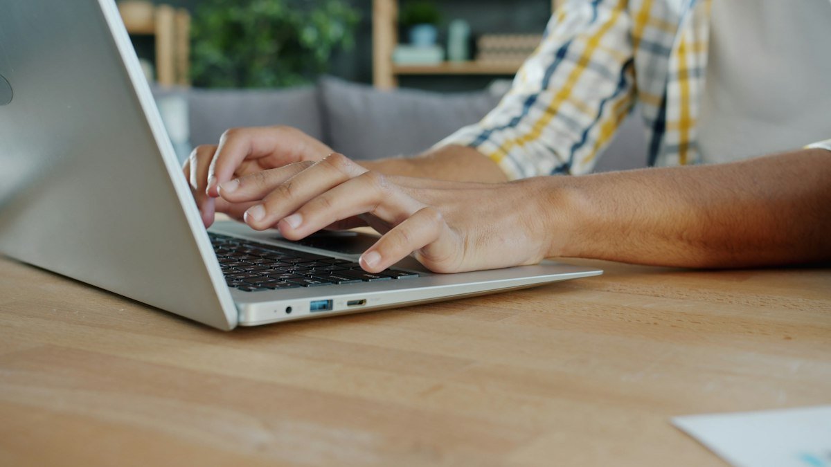 Hands typing a sample Upwork proposal for beginners